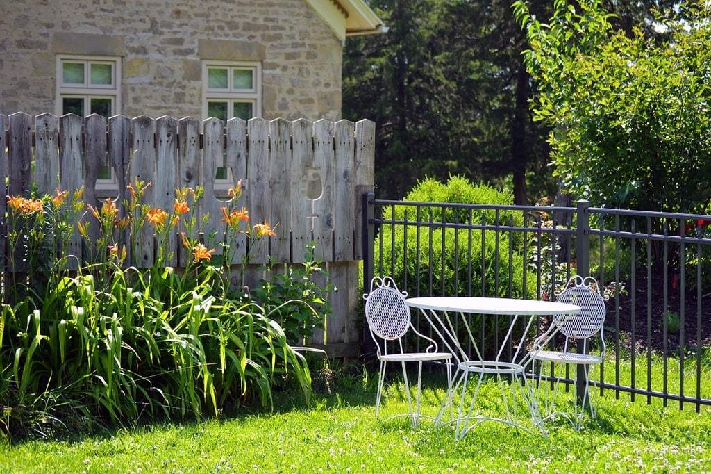 Installer une clôture en bois ou en métal selon style jardin